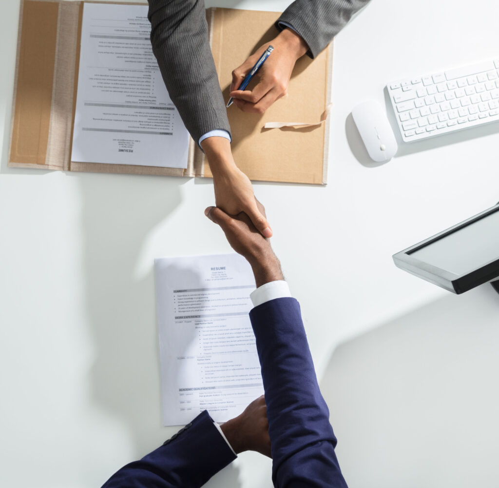Advisor and client shaking hands over registration paperwork