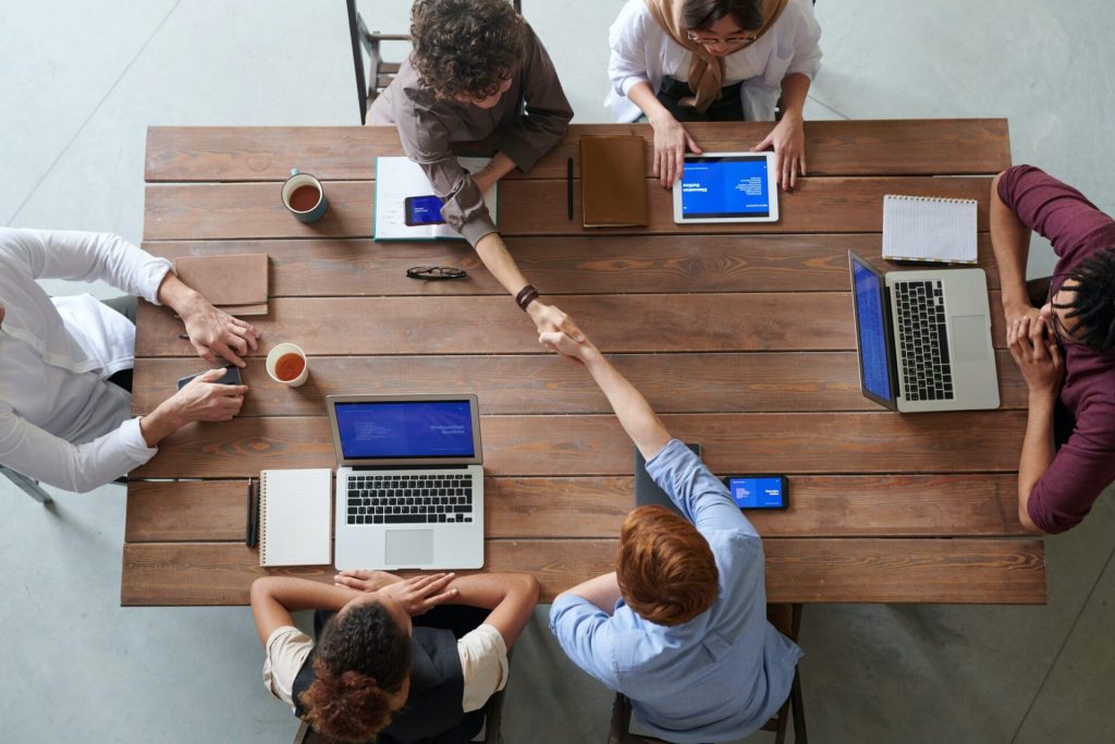 A company team managing its administration online around a shared table